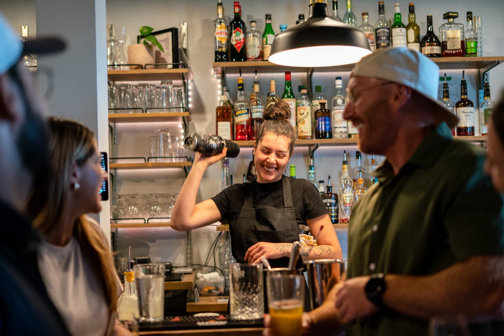 Véronique prépare un cocktail derrière le bar